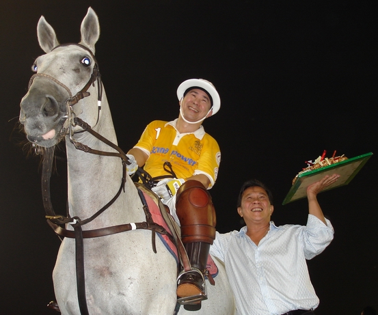 Khun JJ presenting the Birthday Cake to Khun Vichai inbetween chukkas.